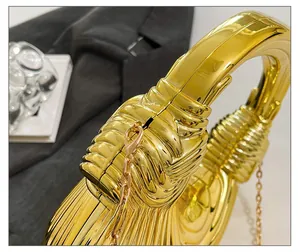 Detailed macro shot of the golden pleated texture and luxury metal clasp of the handbag