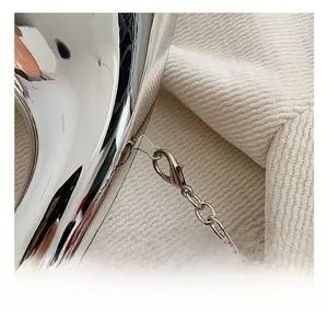 Detail eines hochwertigen silbernen Karabinerverschlusses und einer Kette an Abendtasche