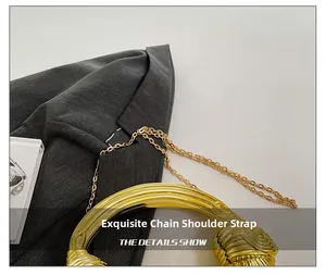 Detailed close-up of golden metal ring handle and exquisite chain shoulder strap on the bag