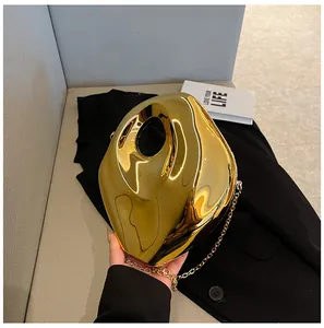 Close-up of golden irregular geometric metal evening bag with glossy mirror finish