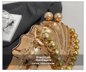 Detail of high-quality golden hardware and pearl chain on a shell-shaped clutch bag