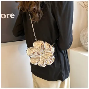 Modella che indossa una borsa a fiore 3D argento con tracolla a catena in metallo