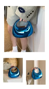 Vue détaillée du sac à main croissant bleu électrique avec fini métallique et chaîne dorée