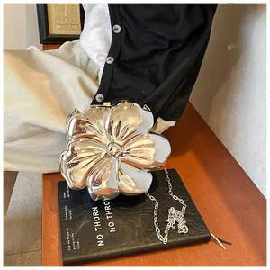 Dettaglio della pochette rigida a forma di fiore argento con sottile tracolla a catena