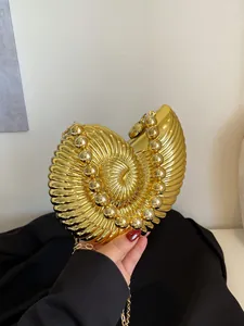 Gros plan sur la pochette nautile dorée avec texture radiale et bordure en perles