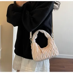 Detail of light pink quilted hobo bag with silver rhinestones and adjustable strap