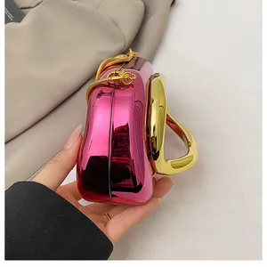 Detail of rose pink metallic evening bag with round gold handle and snake chain strap