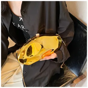 Detail of a shiny gold pebble-shaped acrylic evening bag with a metallic chain strap
