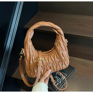 Detail view of brown pleated hobo bag with sparkling rhinestones and woven handle