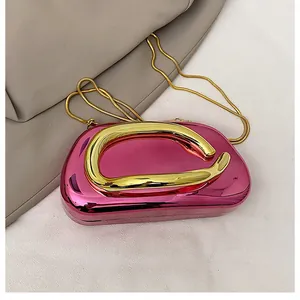 Close-up of rose red metallic evening bag with sleek gold handle and chain detail