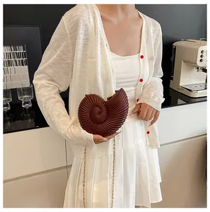 Détail du sac bandoulière marron en forme de coquille avec texture spirale 3D nautile