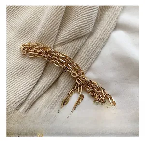 Détail d'une bandoulière en chaîne dorée polie avec une finition brillante élégante
