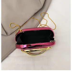 Detailed interior of pink metallic evening bag with gold handle and black lining