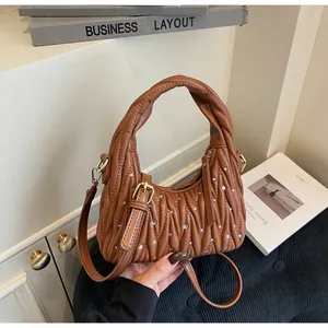 Detail of brown pleated quilted handbag with rhinestone accents and gold hardware