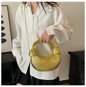 Detail of gold metallic woven handbag featuring a spiral handle and chain strap