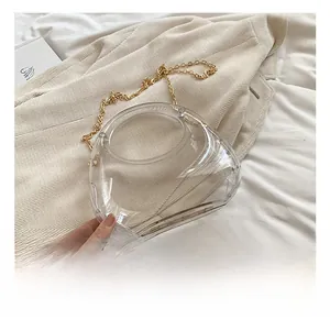 Détails d'un sac triangle en acrylique transparent avec une chaîne en métal doré