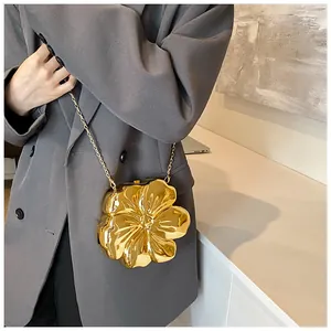 Vista dettagliata di una pochette a fiore dorato in metallo con elegante tracolla a catena