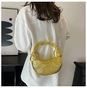Rear view of gold wave texture bag with round metal handle and delicate chain strap