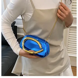 Close-up of luxury bright blue metallic evening clutch bag with gold ring handle and chain