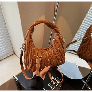 Detailed view of a brown pleated handbag featuring sparkling rhinestones and gold hardware