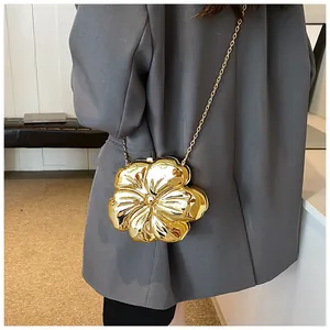 Dettaglio borsa a fiori dorata con finitura a specchio su una giacca blazer grigia