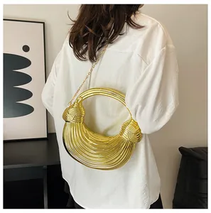Detail of a gold metallic pleated handbag with a round handle and slim chain strap