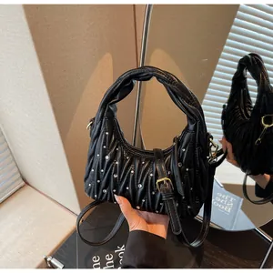 Detail view of black pleated PU leather bag with rhinestones and twisted handle