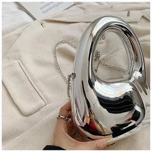 Detailsicht der silbernen Metallic-Acryl-Clutch mit rundem Griff und Kettenriemen