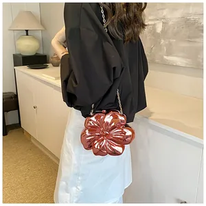 Dettaglio della pochette a fiore in metallo oro rosa con petali 3D e tracolla a catena
