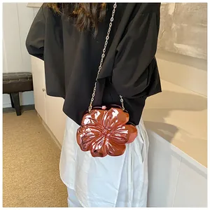 Dettaglio di una borsa a catena a forma di fiore oro rosa metallizzato su una modella