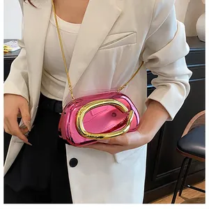 Detail of rose pink metallic evening bag with large gold C hardware and chain strap