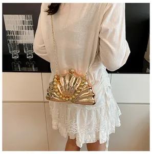 Detail of creative gold seashell evening clutch bag with wave texture and bead trim