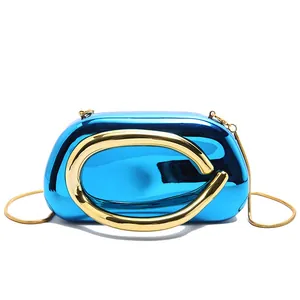Macro detail of luxury blue mirror evening clutch with gold circular ring buckle