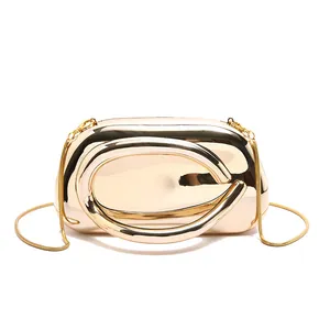 Close-up of gold mirror evening clutch with curved handle and fine snake chain