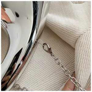 Nahaufnahme der silbernen Metallkette mit Karabinerverschluss an der Acryl-Abendtasche