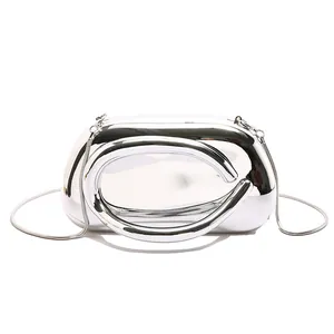 Close-up of silver mirror luxury evening clutch with sculptural handle and chain strap
