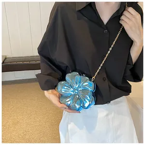 Dettaglio borsa a tracolla a forma di fiore blu metallizzato con catena dorata