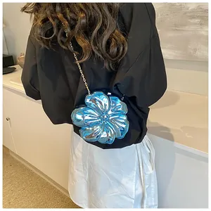 Dettaglio borsa a fiore blu specchiato con catena dorata indossata sulla schiena