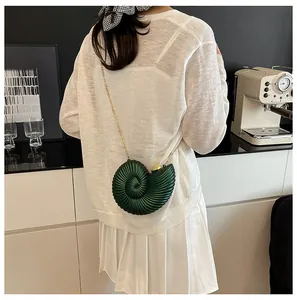 Détails de la texture du sac nautile vert foncé avec bandoulière chaîne en métal doré