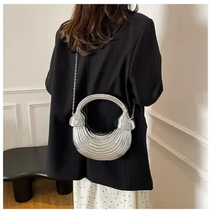 Detail of silver metallic crescent bag with radial pleats and circular handle
