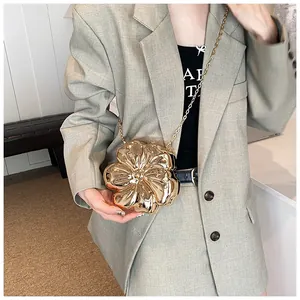 Dettaglio pochette a forma di fiore in metallo dorato con finitura a specchio e catenella