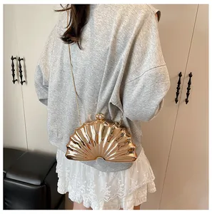 Close-up of golden shell evening clutch with metallic sheen and elegant chain strap