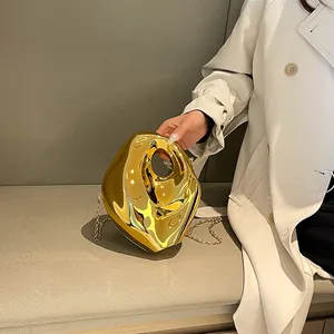 Irregular gold acrylic clutch bag with polished finish and circular cutout handle