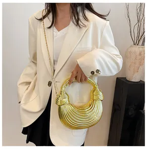 Detail of a metallic gold woven handbag with circular handle and elegant chain strap