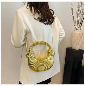 Macro detail of the golden pleated texture and metallic finish on this crescent handbag
