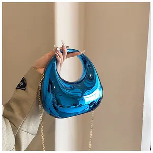 Détail du sac à main en acrylique bleu électrique avec fini miroir brillant et chaîne