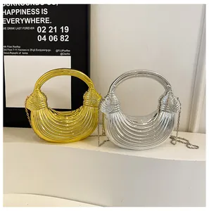 Close-up of gold and silver metallic woven half-moon bags with ring handles and chains