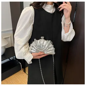 Detail view of silver shell evening clutch bag with pearl trim and metal chain strap