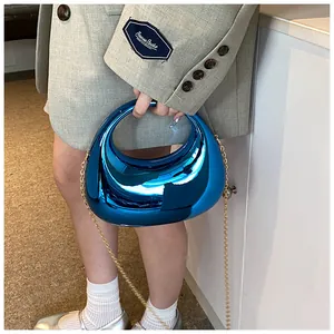 Sac croissant bleu électrique miroir à la mode avec bandoulière dorée sur modèle