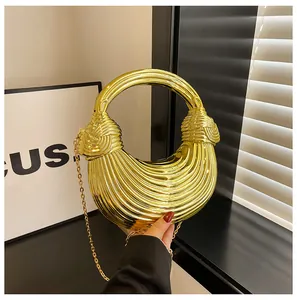 Detail of gold metallic crescent handbag featuring radial pleats and a knot handle